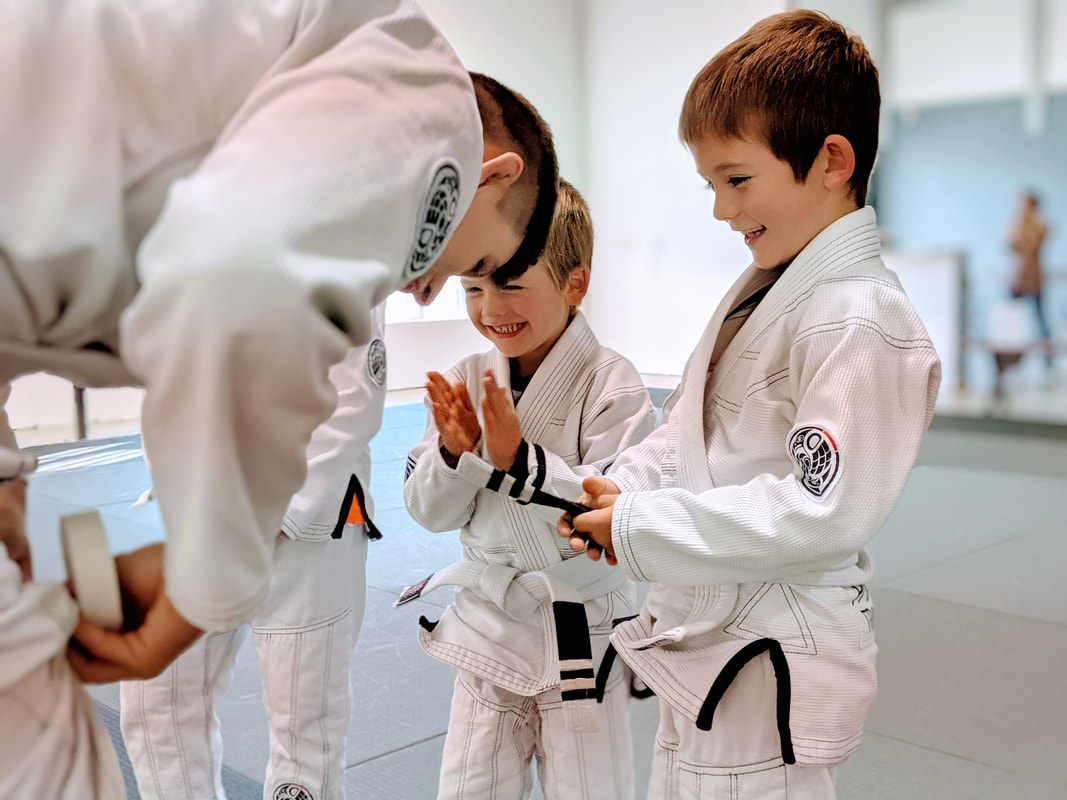 Kids receiving stripes on Brazilian Jiu Jitsu white belts